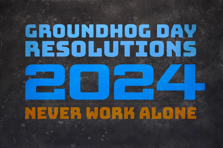 The text 'Groundhog Day Resolutions 2024: Never Work Alone' are projected on a dark wall.