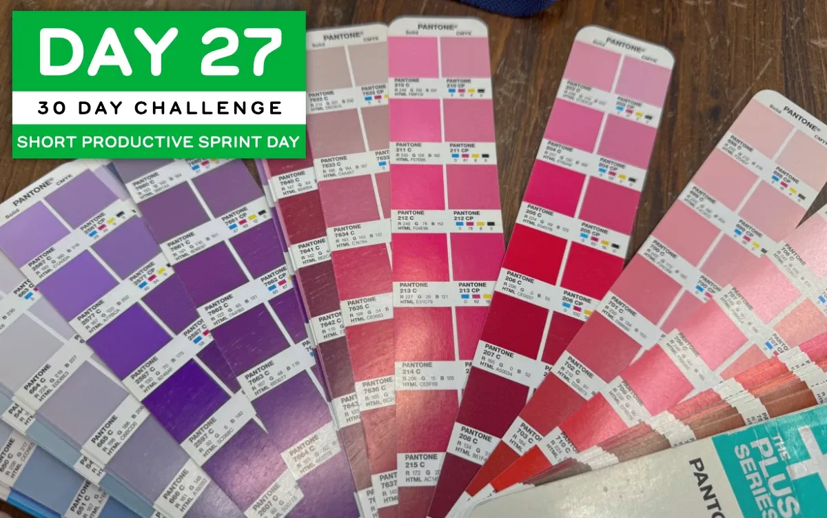 A Pantone Color Bridge guide fanned open, showing dozens of blue-to-fuschia hues in swatches with their color mixing information. (full size image)