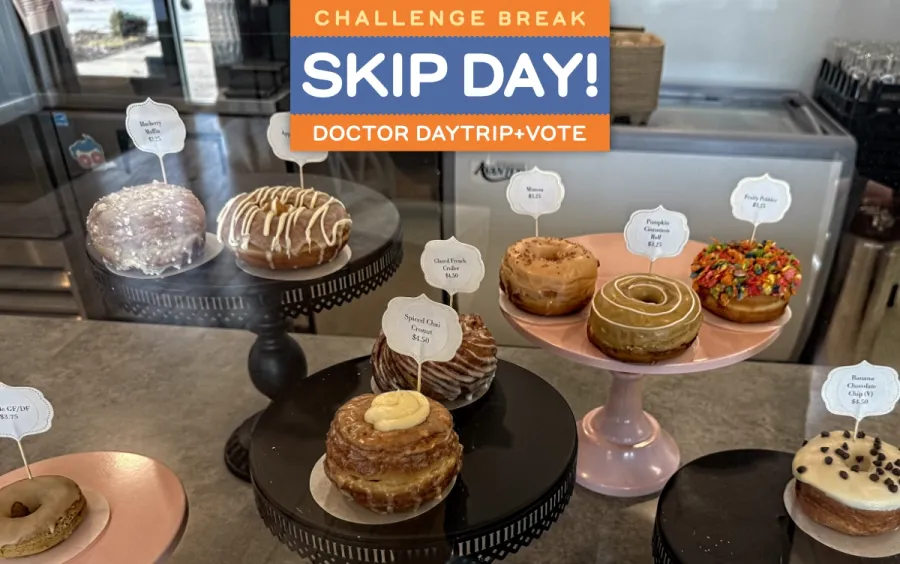 Several kinds of gourmet donuts on individual cake trays, a delicious variety of filled donuts, crullers, and cronuts.