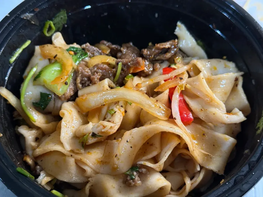 Closeup of Xi'an Biang Biang Noodles, thick hand-cut pasta with cumin-seasoned beef
