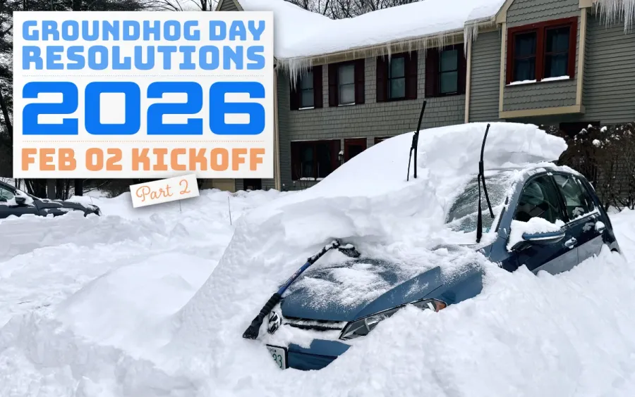 A car buried by two feet of snow, with only a small part of it excavated and visible.