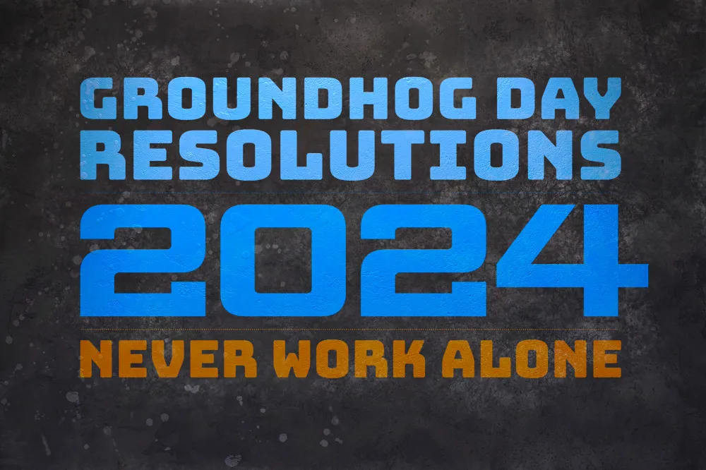 The text 'Groundhog Day Resolutions 2024: Never Work Alone' are projected on a dark wall. (full size image)